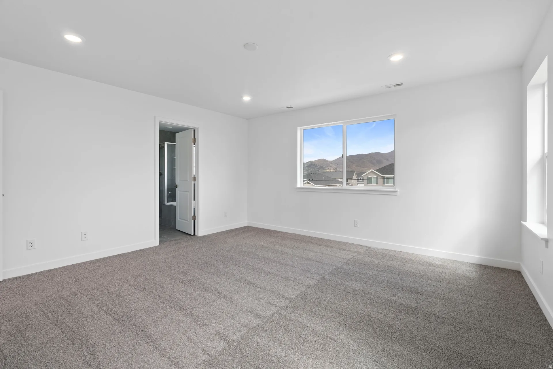 Spacious room featuring neutral carpet flooring and recessed lighting