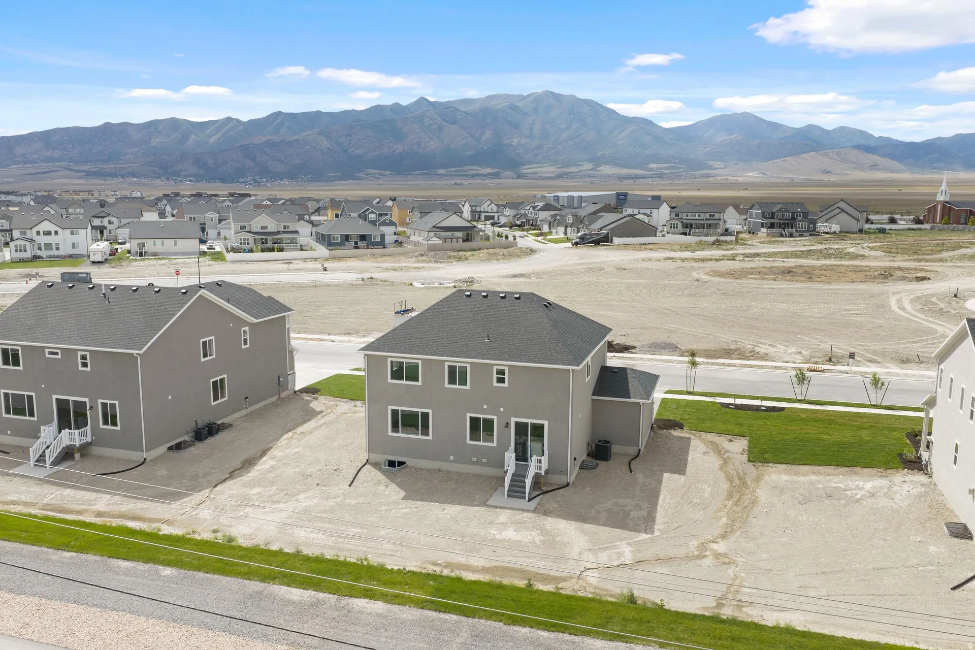 Contemporary gray exterior with white trim, a dark shingle roof, and a rear walk-out basement