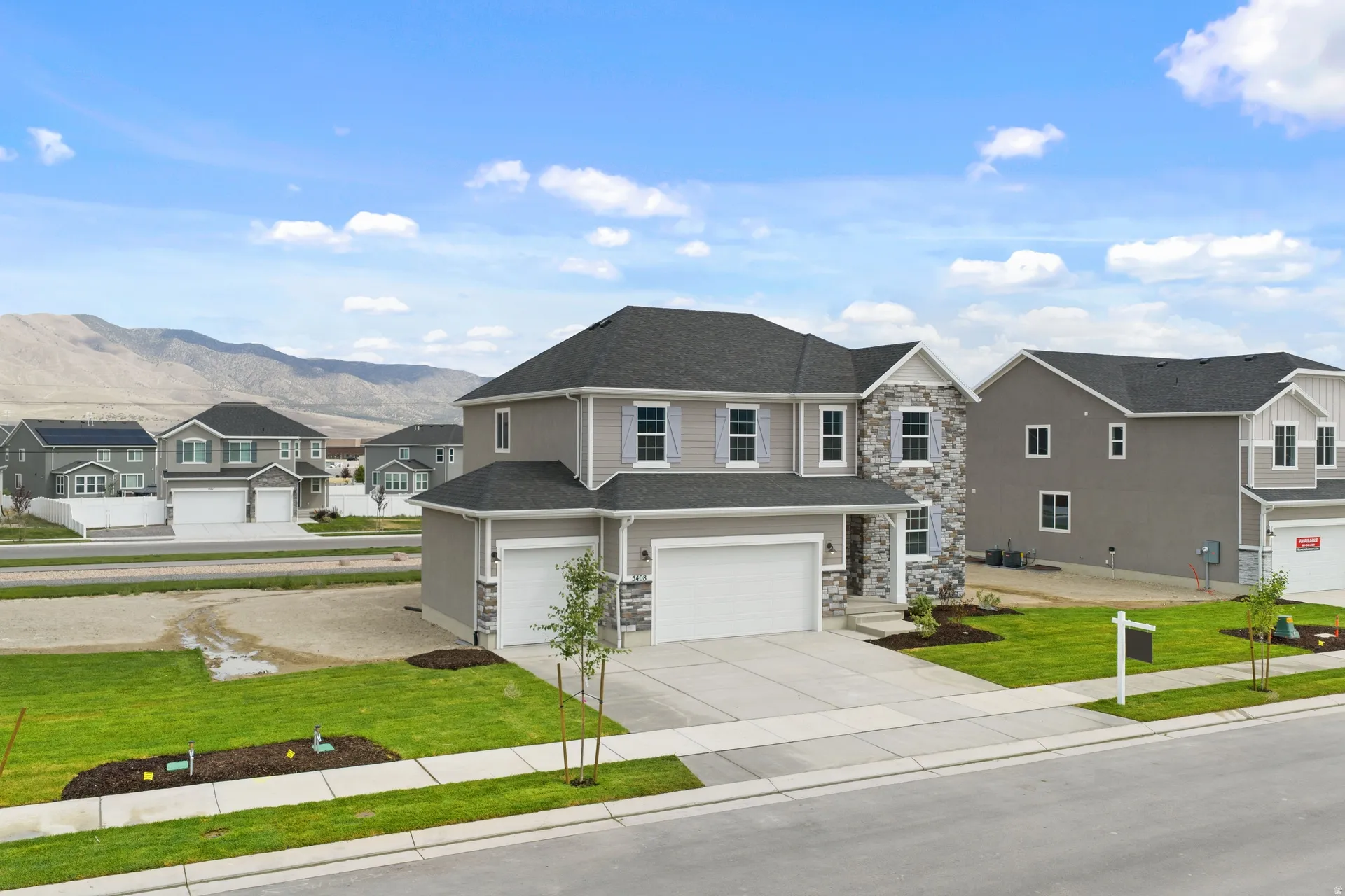 Contemporary two-story residence featuring a gray exterior with stone and siding accents