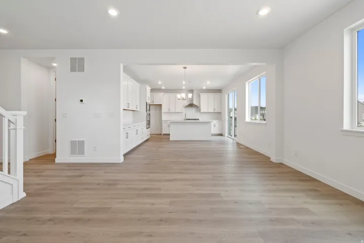Spacious interior featuring wood-finish flooring, white walls, and recessed lighting