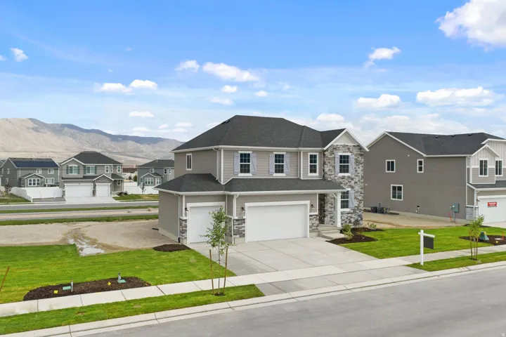 Contemporary two-story residence featuring a gray exterior with stone and siding accents