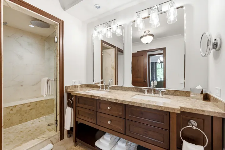 Bathroom featuring a double vanity with stone countertops, integrated sinks, and dark wood cabinetry