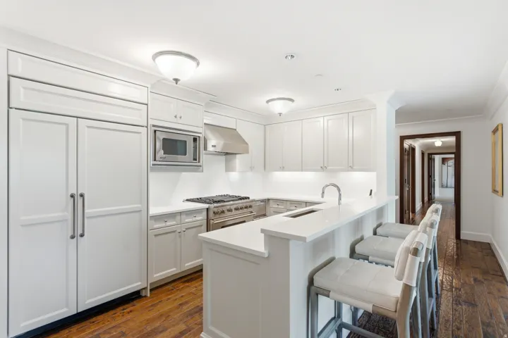 Kitchen featuring white cabinetry, stainless steel appliances, white countertops, and a breakfast bar