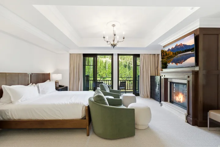 Recessed tray ceiling with a chandelier, built-in fireplace with a stone surround, and an integrated entertainment center