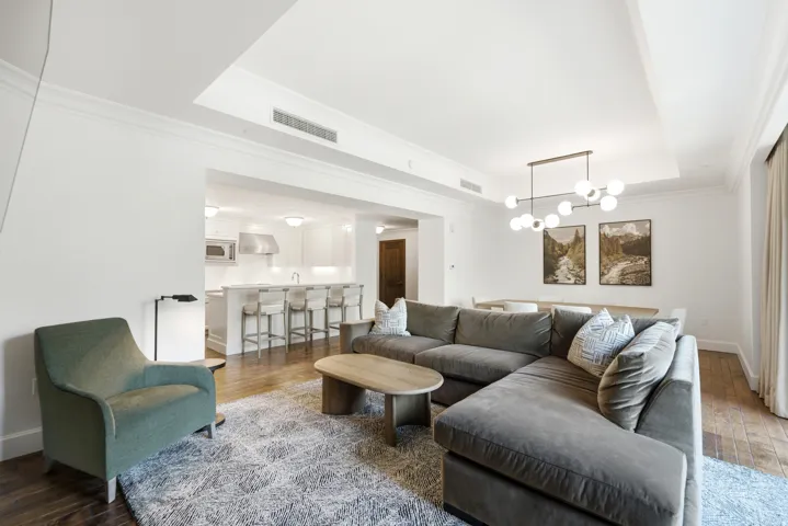 Expansive living area with wood-finish flooring and crown molding
