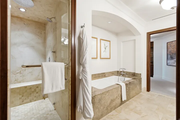 Luxurious bathroom featuring a spacious walk-in shower with a built-in bench and dual shower heads