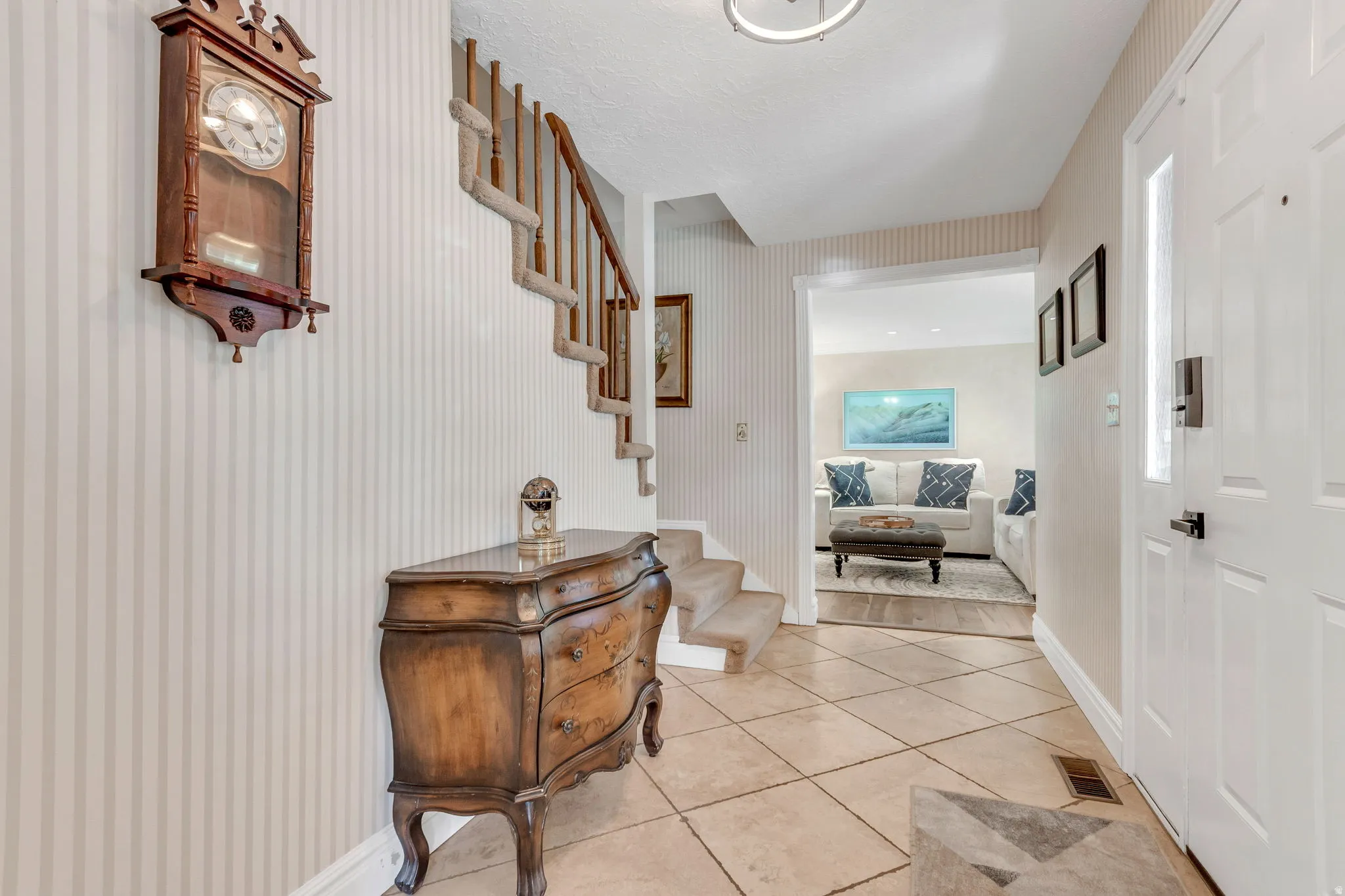 Entryway featuring tile flooring, a staircase with carpeting, and a white paneled door with a frosted glass insert