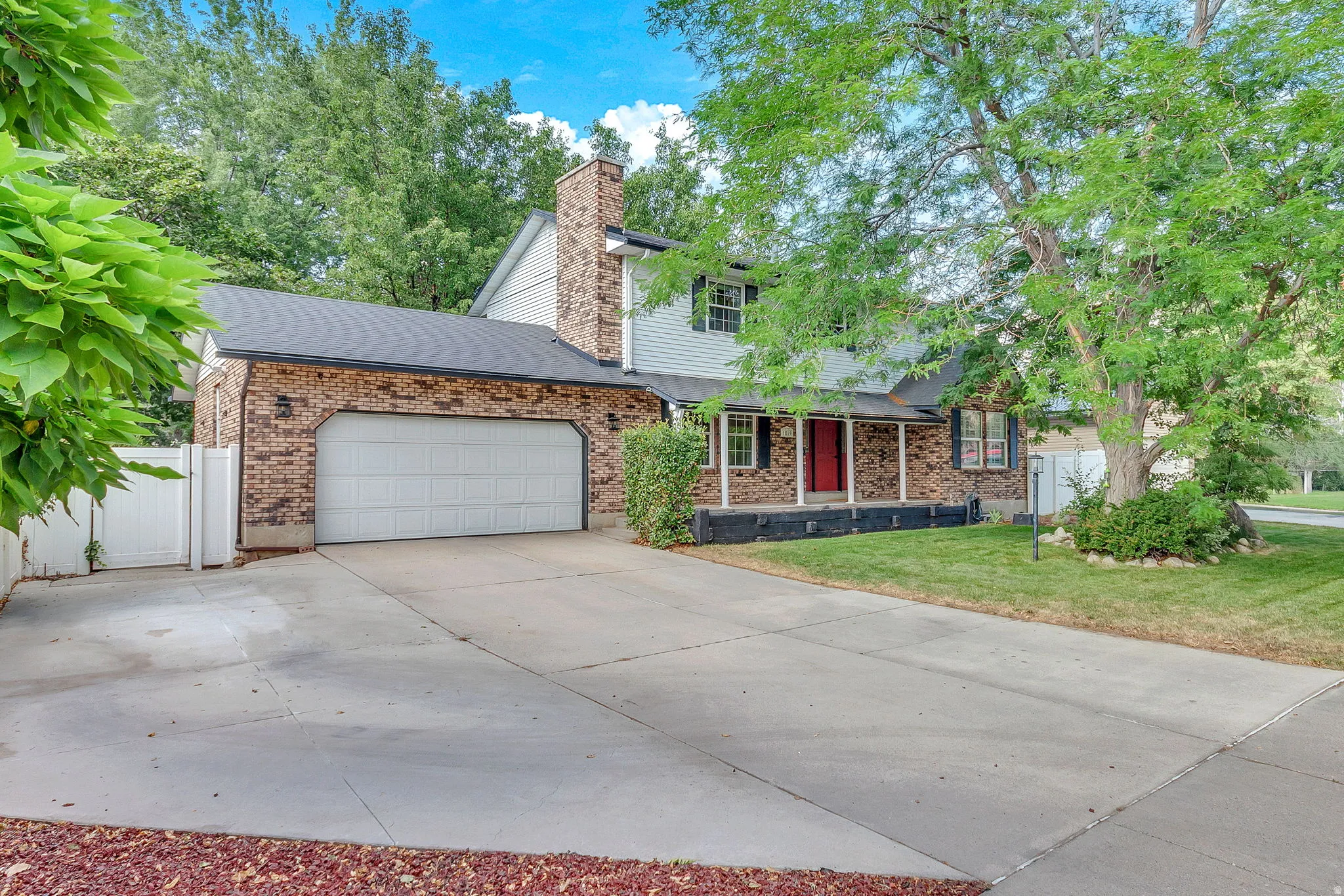 Brick and siding exterior featuring a prominent two-car garage with a panel door