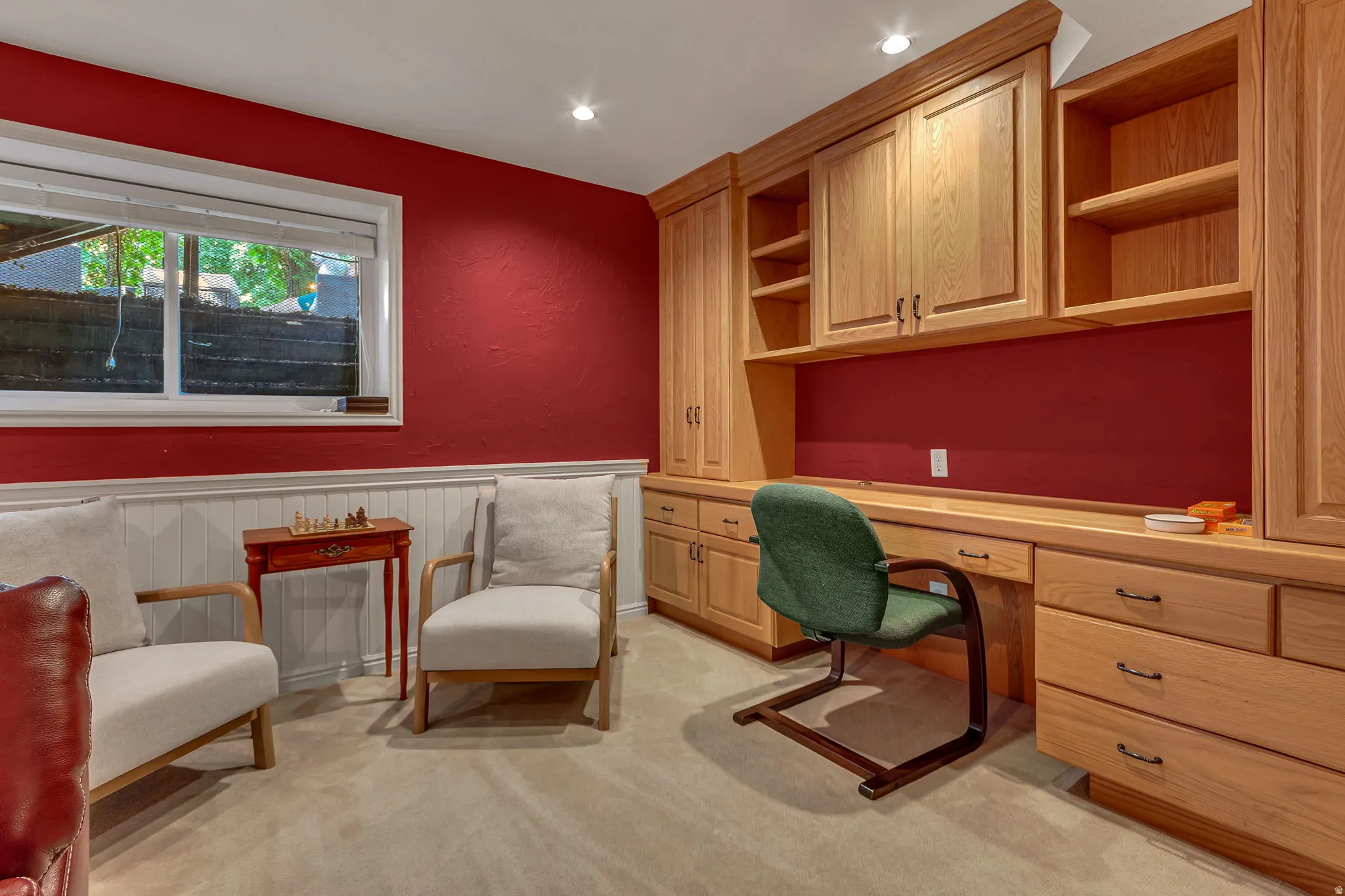 Basement great room. Built-in wood cabinetry with integrated desktop, recessed lighting, and a window