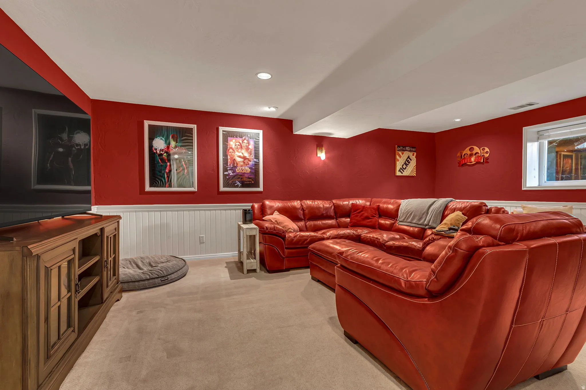 Basement great room. Carpeted room featuring red painted walls with white wainscoting