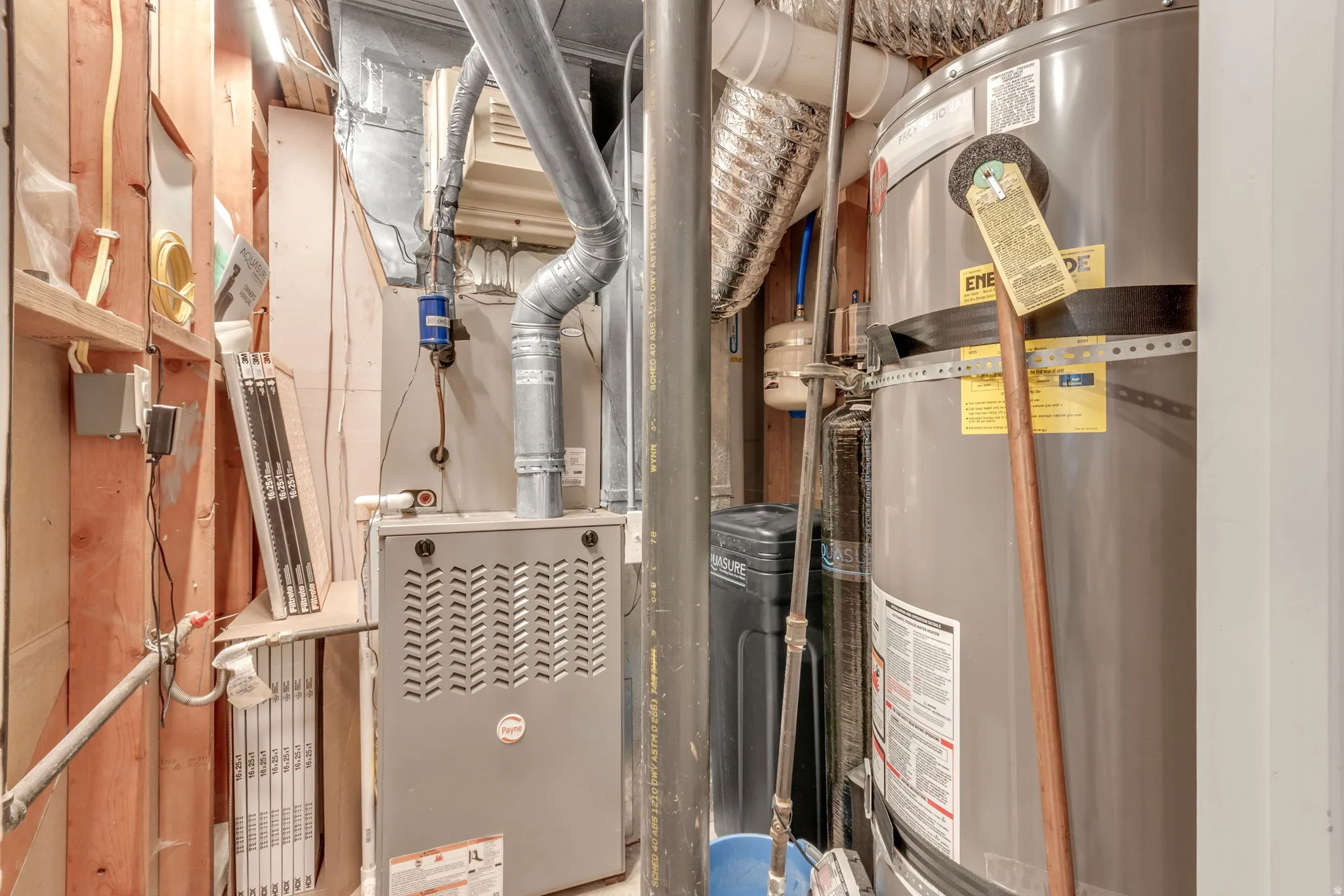 Utility area featuring a water heater, furnace, and water softener system