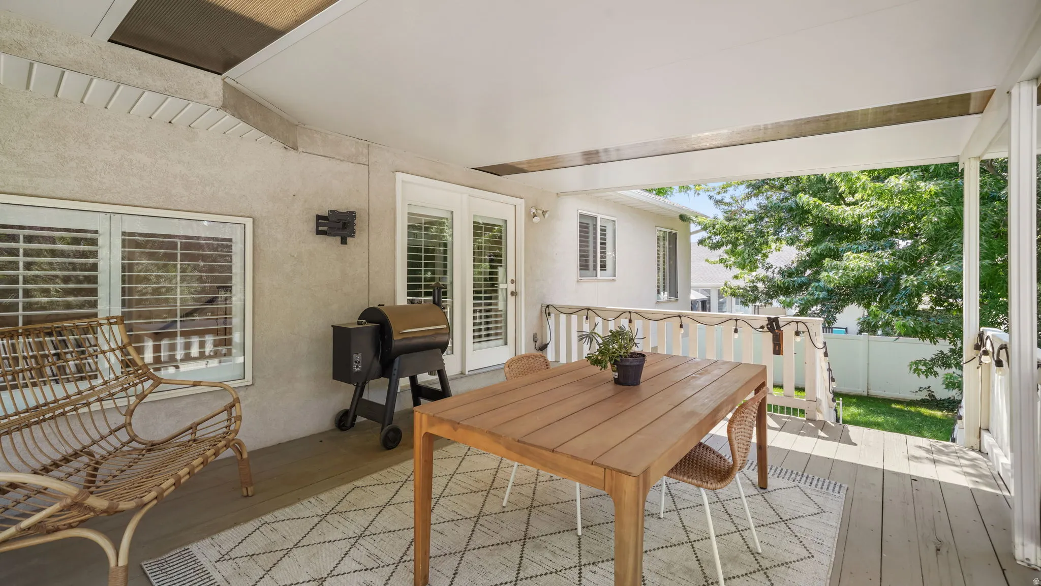 Covered outdoor deck with light wood-finish flooring