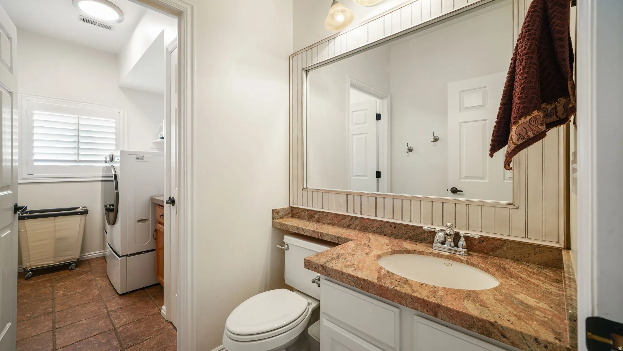 Bathroom vanity featuring an oval undermount sink, a polished chrome faucet, and a spacious granite countertop with an integrated backsplash