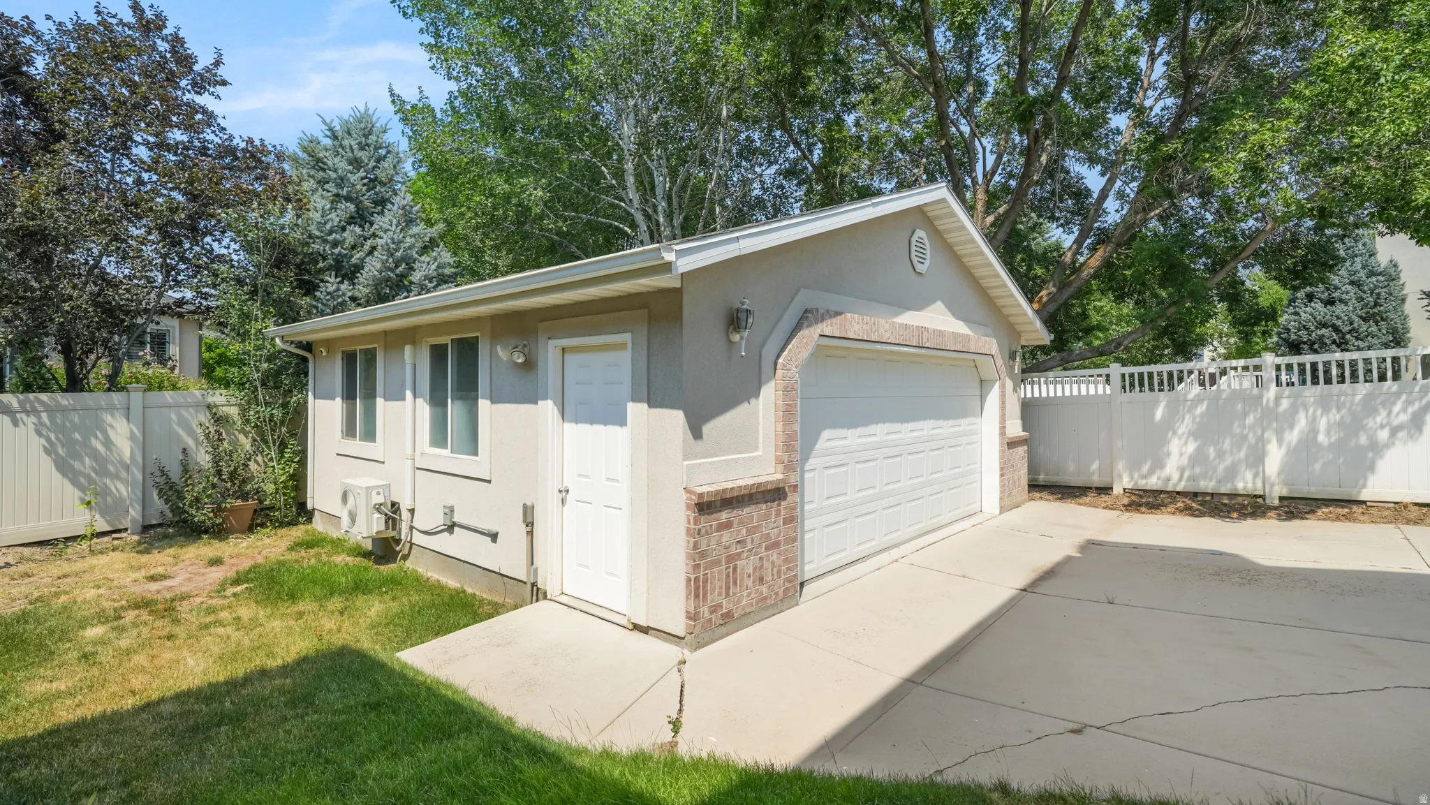 Detached garage building featuring a roll-up door, side entry door, and multiple windows