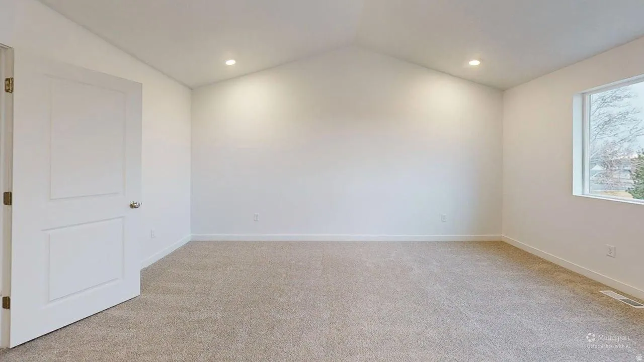 Carpeted room featuring a vaulted ceiling and recessed lighting