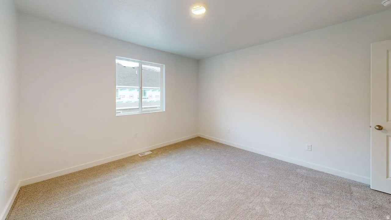 Neutral-toned carpeting spans the room, complemented by white walls and trim