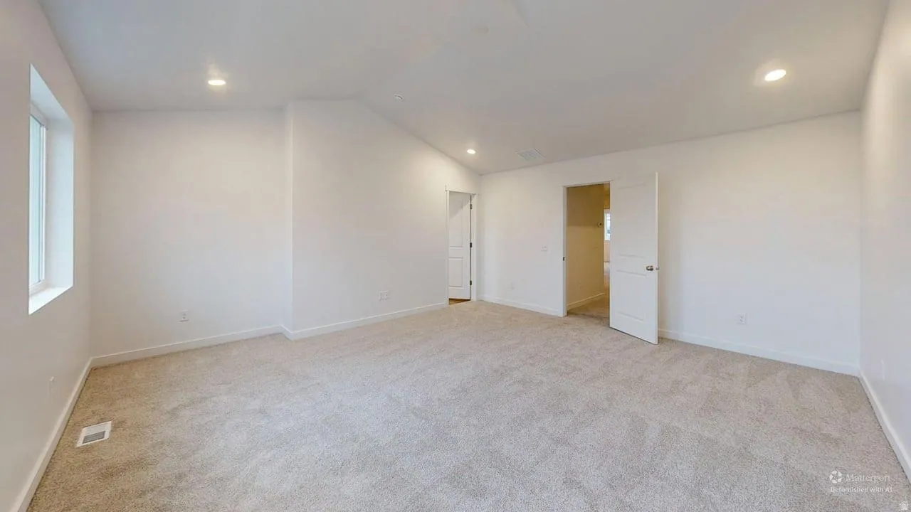 Spacious room featuring light-toned carpet flooring, recessed lighting, white walls, and white trim