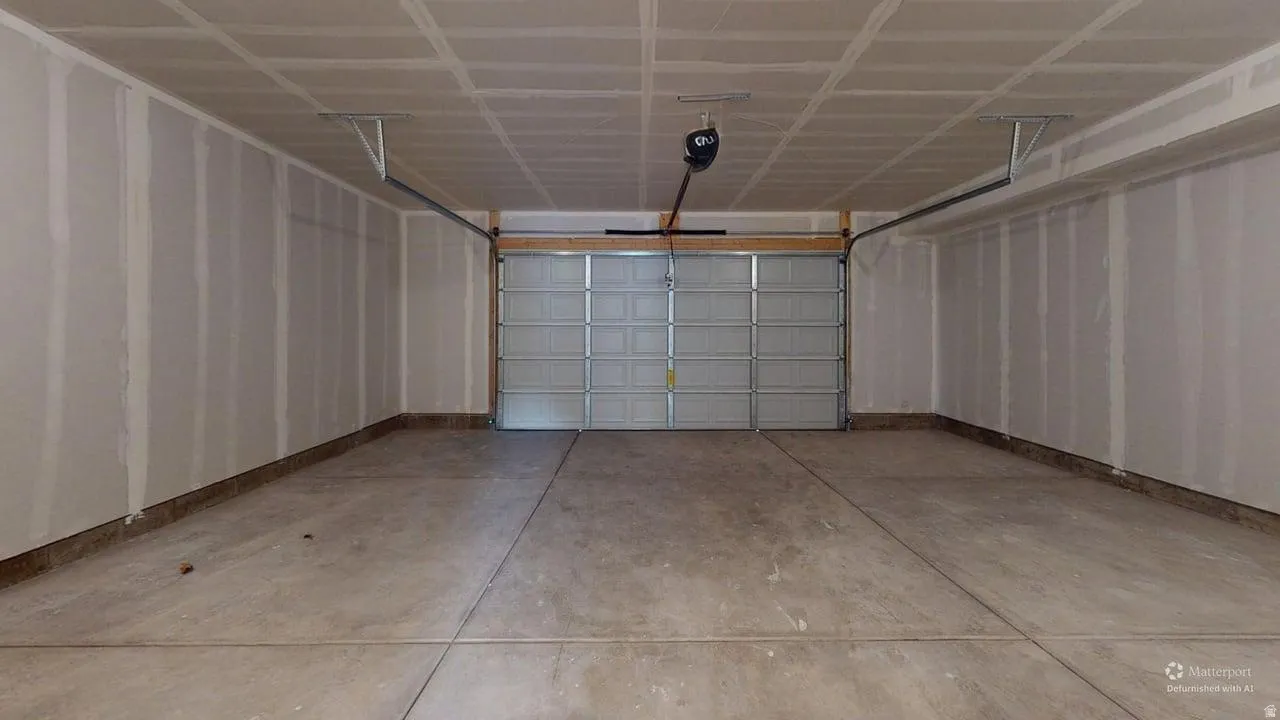 Spacious garage with a sectional overhead door and a ceiling-mounted opener