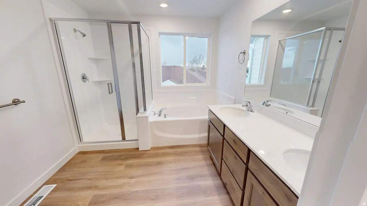 Bathroom featuring a double vanity with stone-finish countertop, wood-finish cabinetry, and undermount sinks