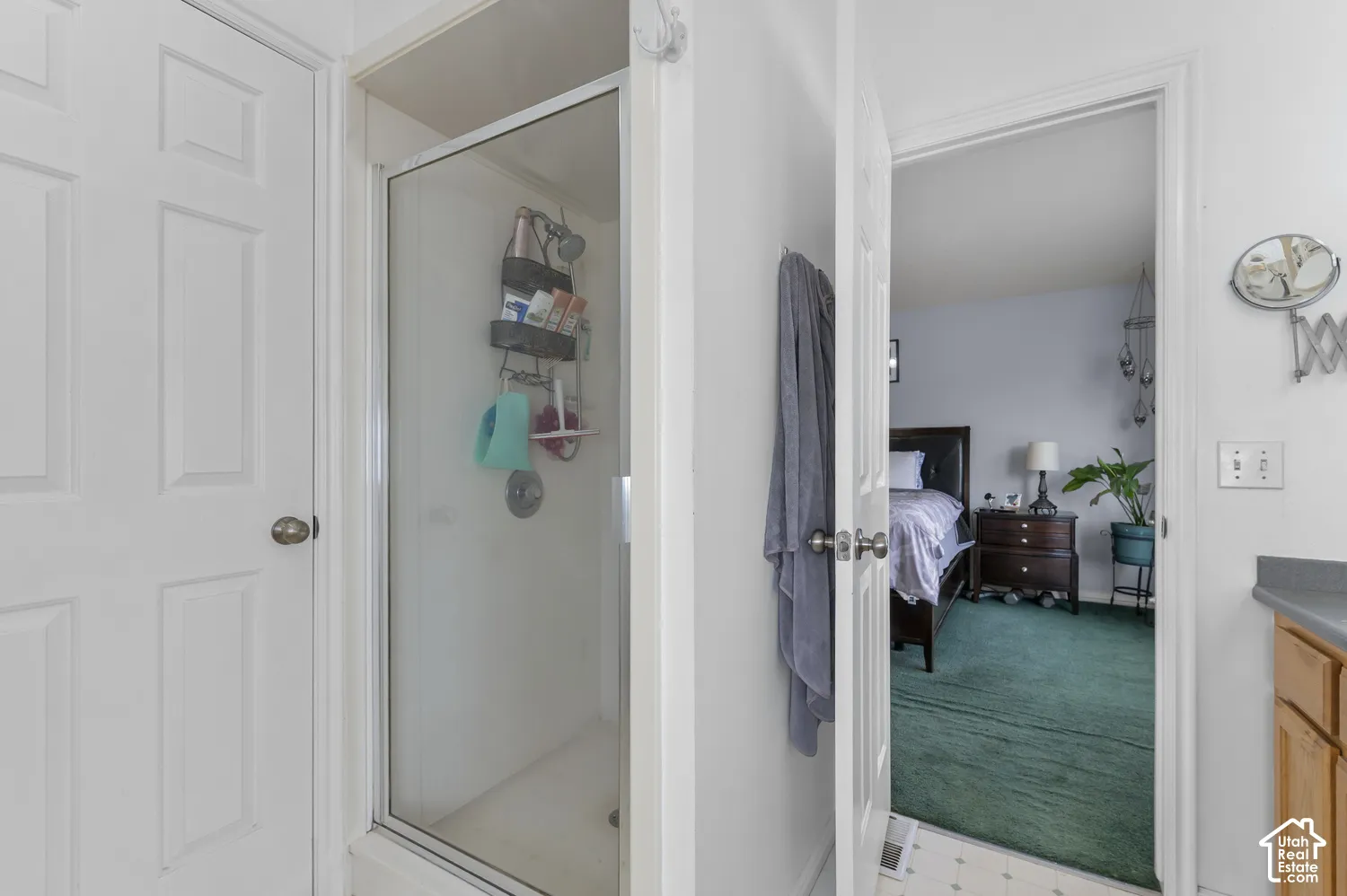 Glass-enclosed shower with a white surround and chrome fixtures
