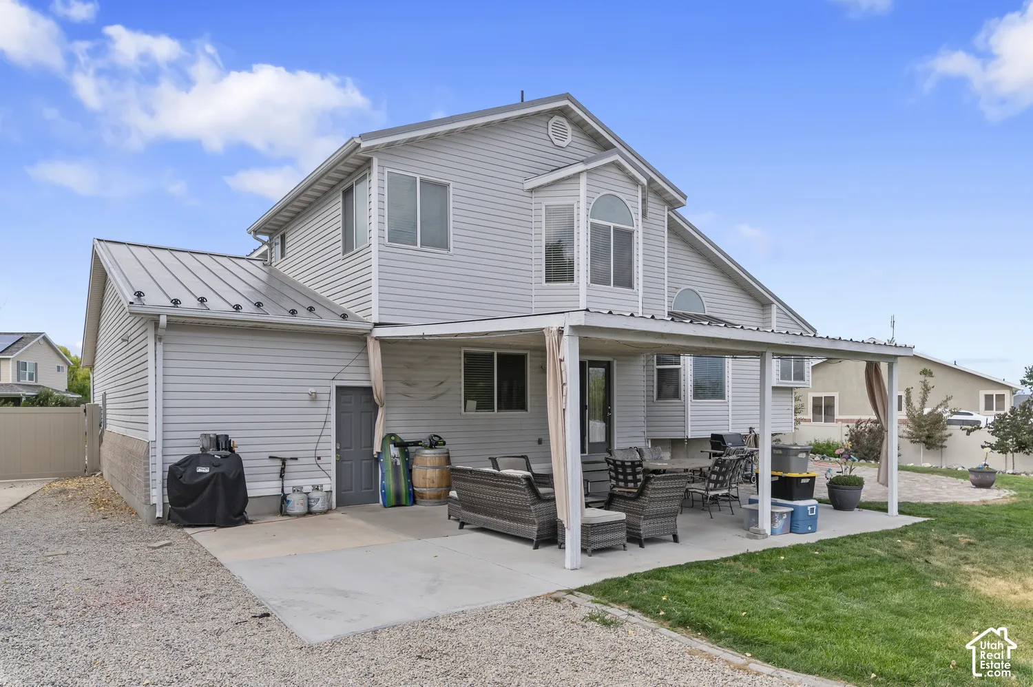 Covered concrete patio extending from the rear of the property