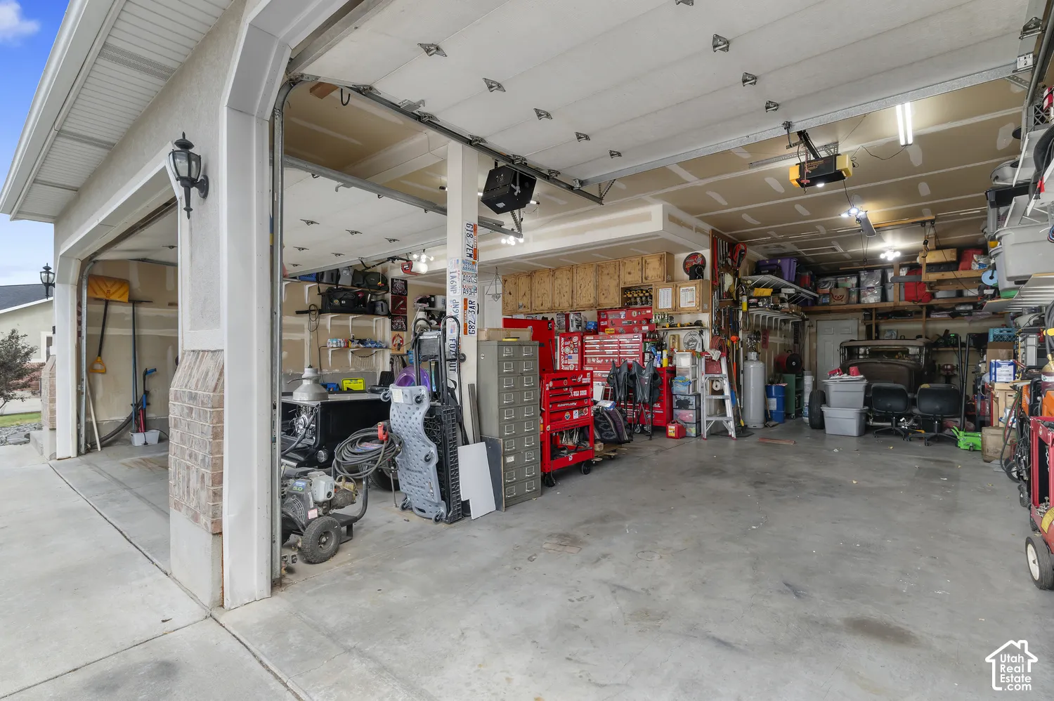 Spacious garage with multiple overhead doors, concrete flooring, and ample overhead lighting