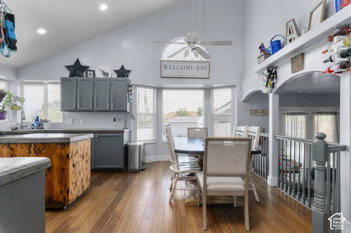 Open concept kitchen and dining area with vaulted ceilings and wood-finish flooring