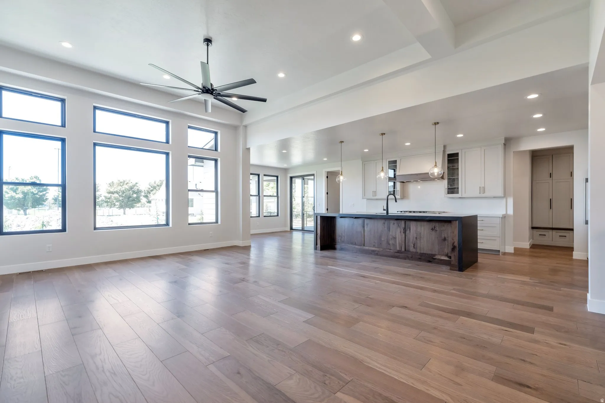 Open-concept living space featuring wood-finish flooring, a contemporary ceiling fan, and recessed lighting