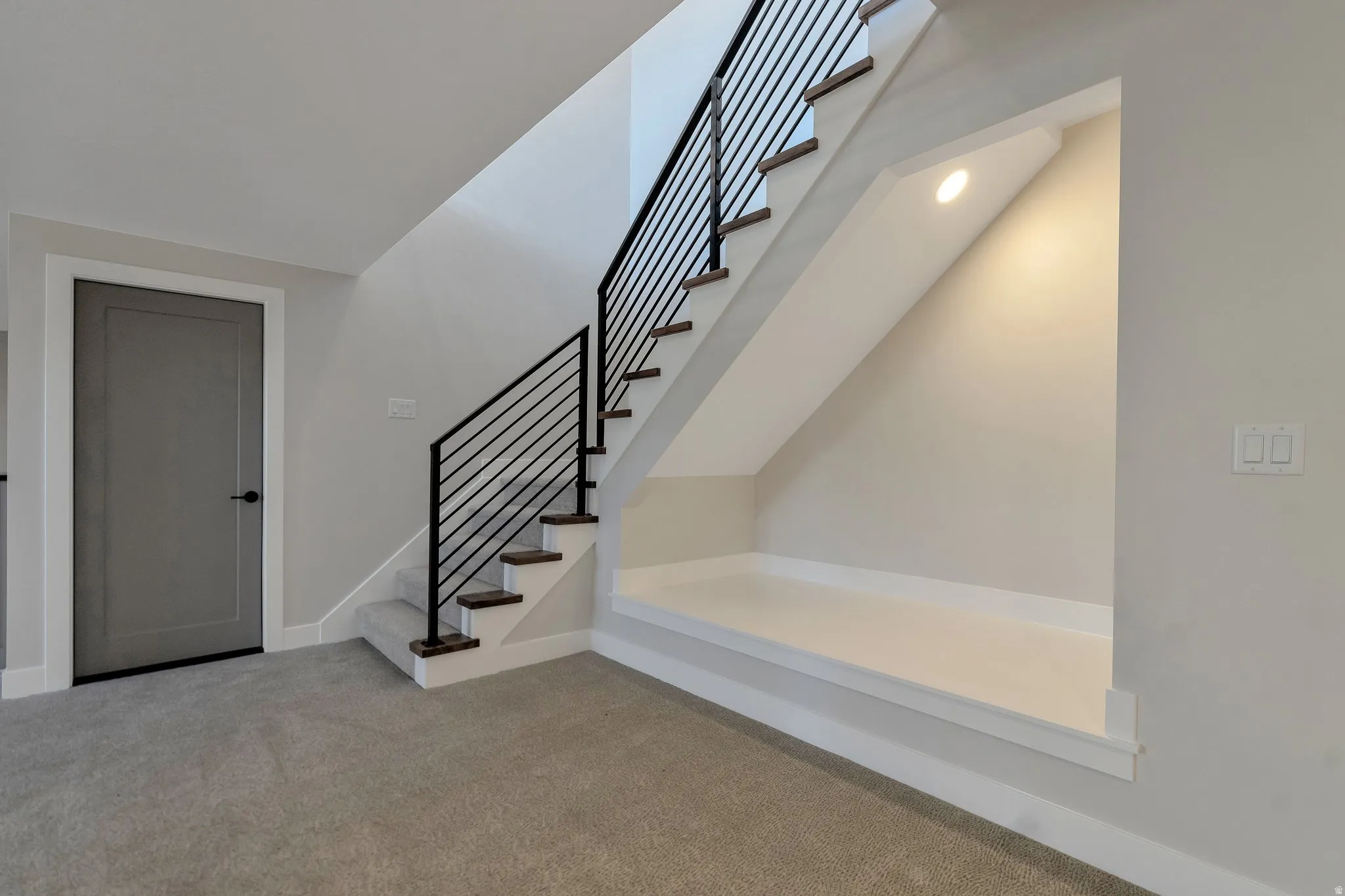 Modern staircase featuring black metal railings and wood-finish treads