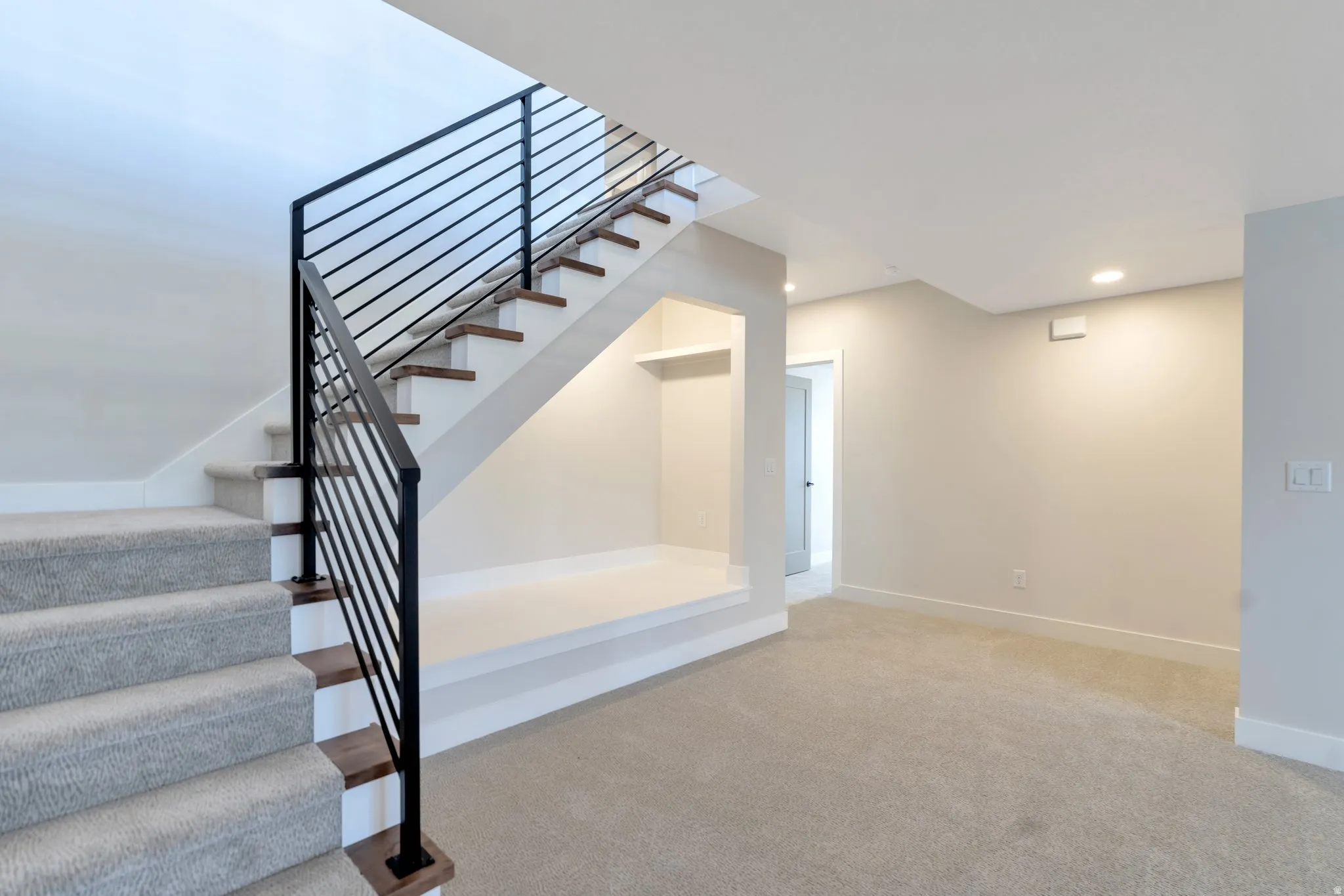 Modern staircase featuring a black metal railing and wood-finish treads