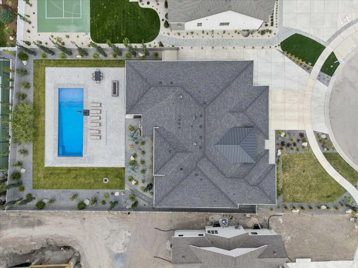 Expansive property featuring a rectangular pool, paver patio, and surrounding green lawn