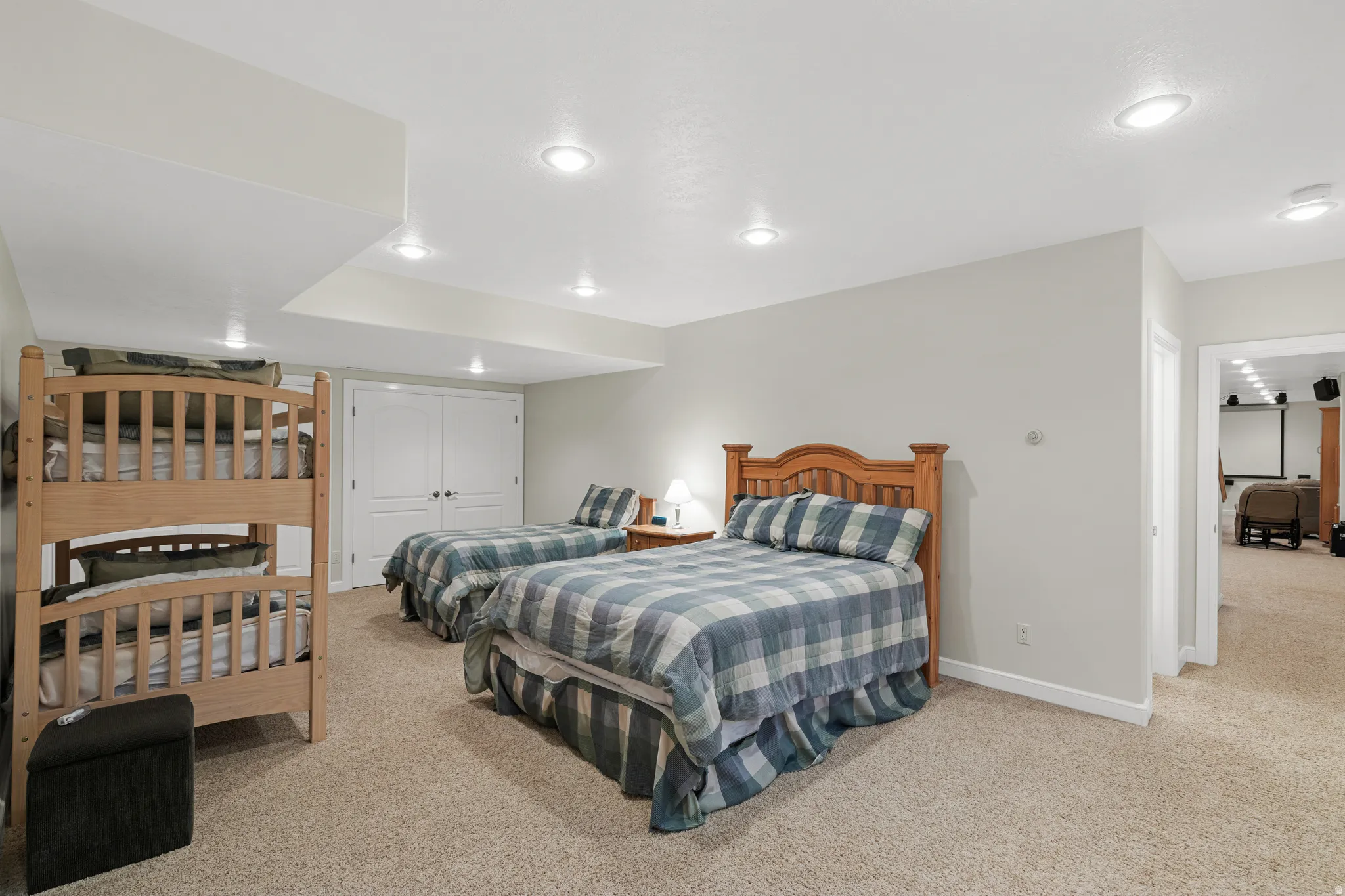 Recessed lighting illuminates neutral-toned walls and plush carpeting