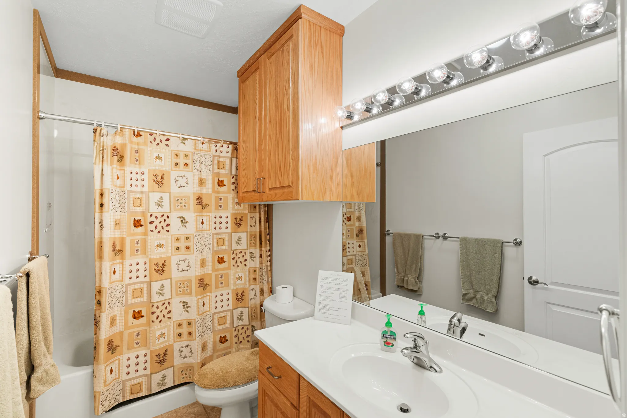 Bathroom featuring a single vanity with a white countertop, chrome faucet, and integrated sink