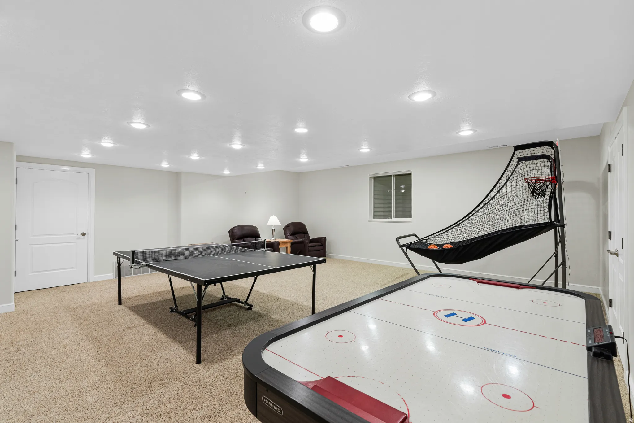 Carpeted room featuring recessed lighting, a window with horizontal blinds, and white interior doors