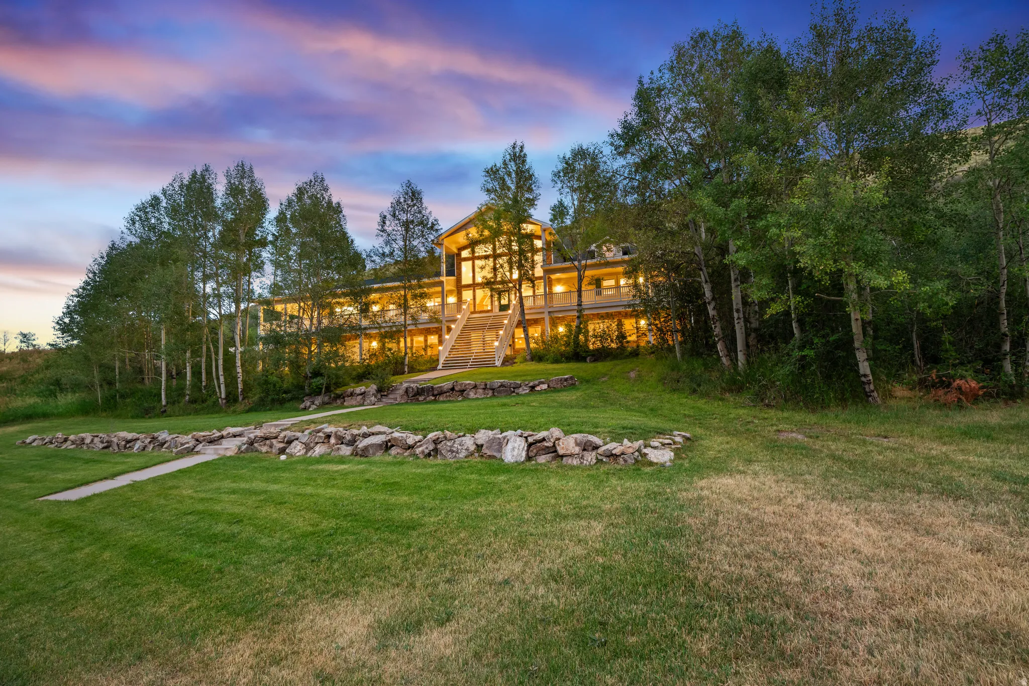 Expansive hillside residence featuring a multi-story design with extensive glass facade and multiple balconies