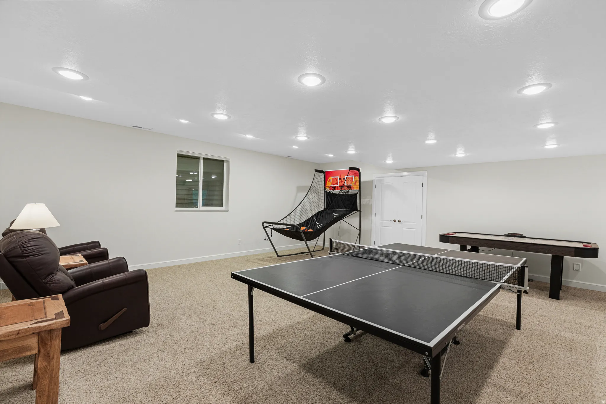 Spacious recreation room featuring recessed lighting, a neutral carpet, and light-toned wall finishes