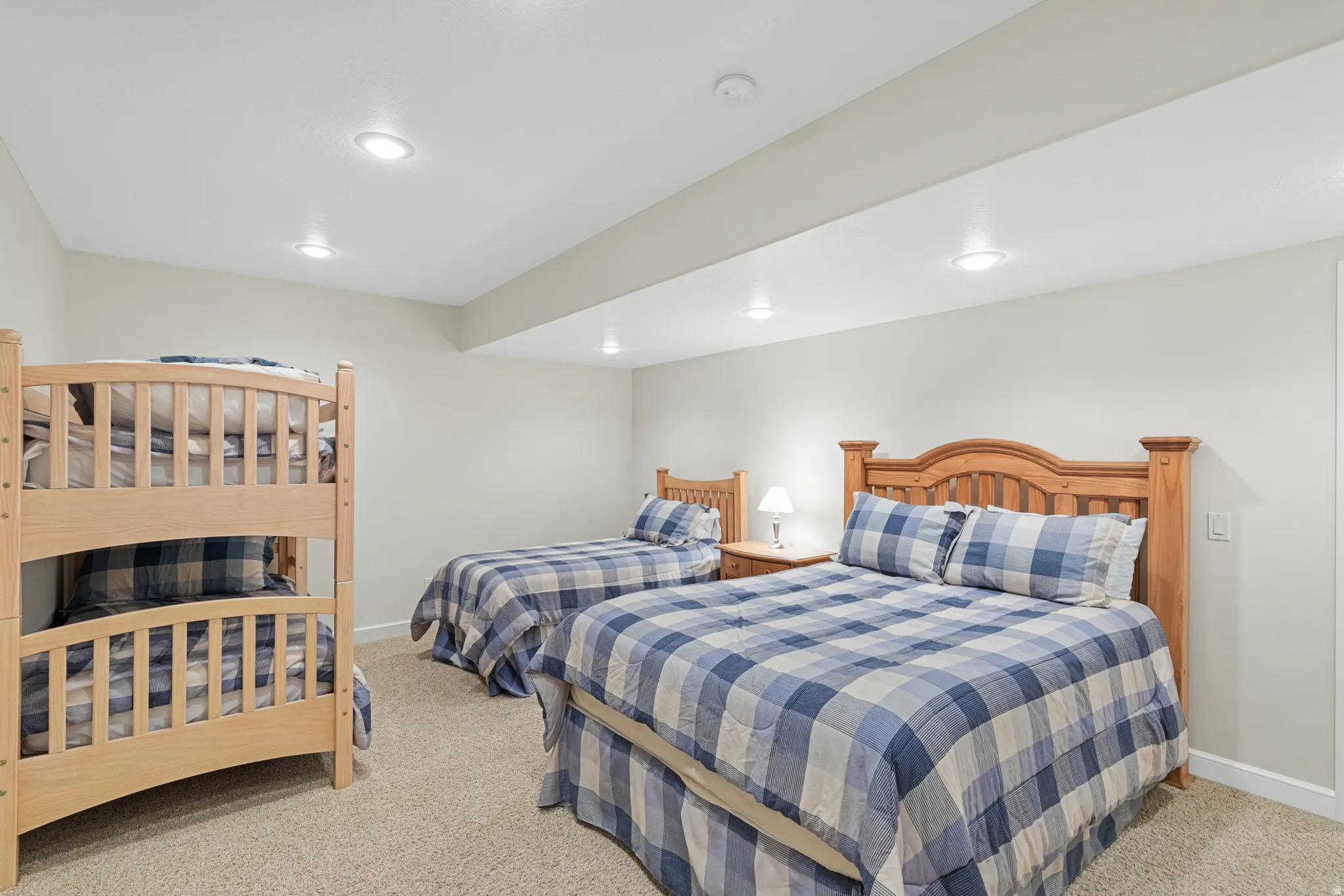 Carpeted room featuring multiple beds, recessed lighting, and light-toned walls