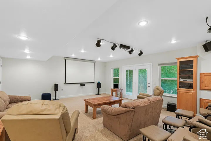 Dedicated entertainment area featuring a projector screen, recessed lighting, and track lighting