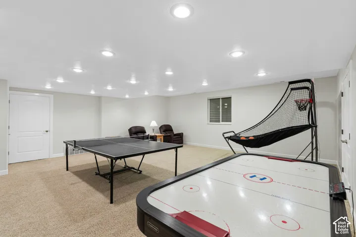 Carpeted room featuring recessed lighting, a window with horizontal blinds, and white interior doors