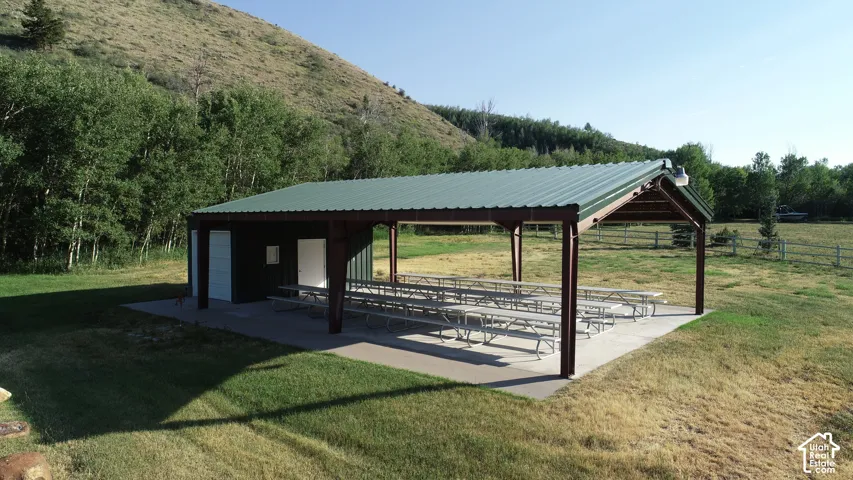 Expansive covered pavilion featuring an enclosed building, substantial support beams, and a concrete slab foundation