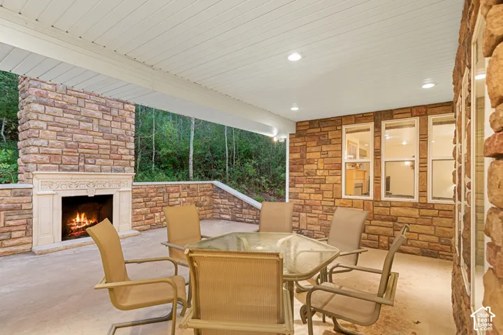 Covered patio featuring a stone-clad exterior with an integrated fireplace and decorative mantel