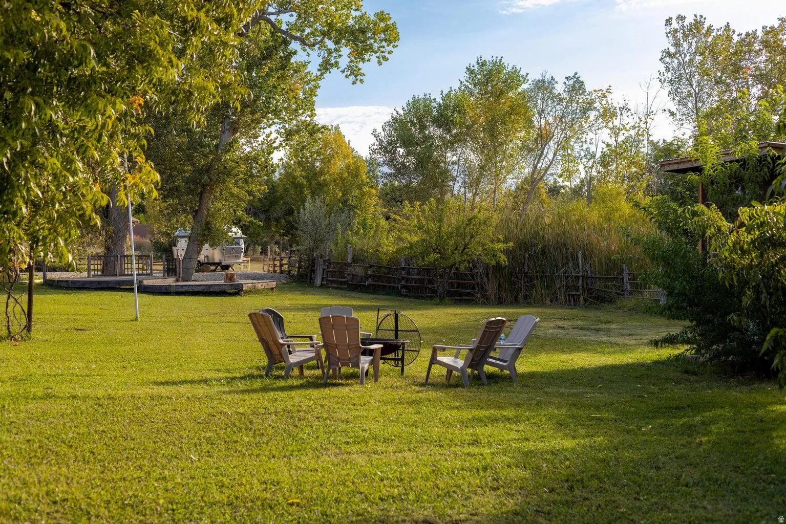 Expansive lawn area featuring a circular fire pit and surrounding chairs