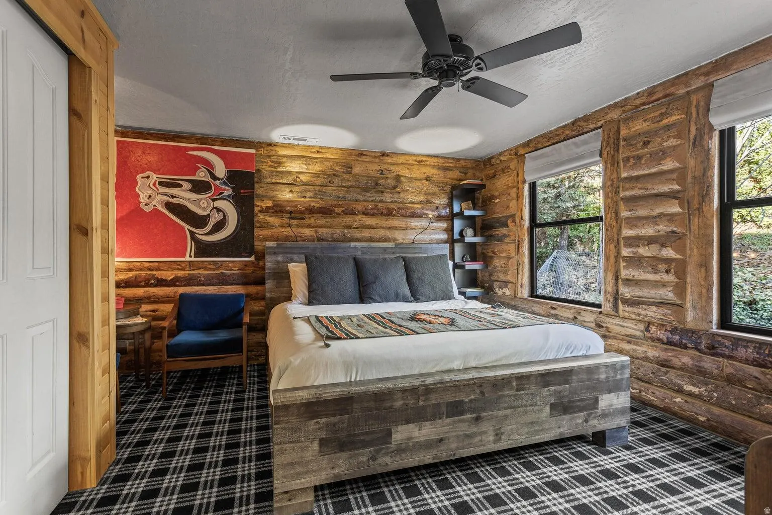 Bedroom featuring rich wood-paneled walls and a plaid patterned carpet