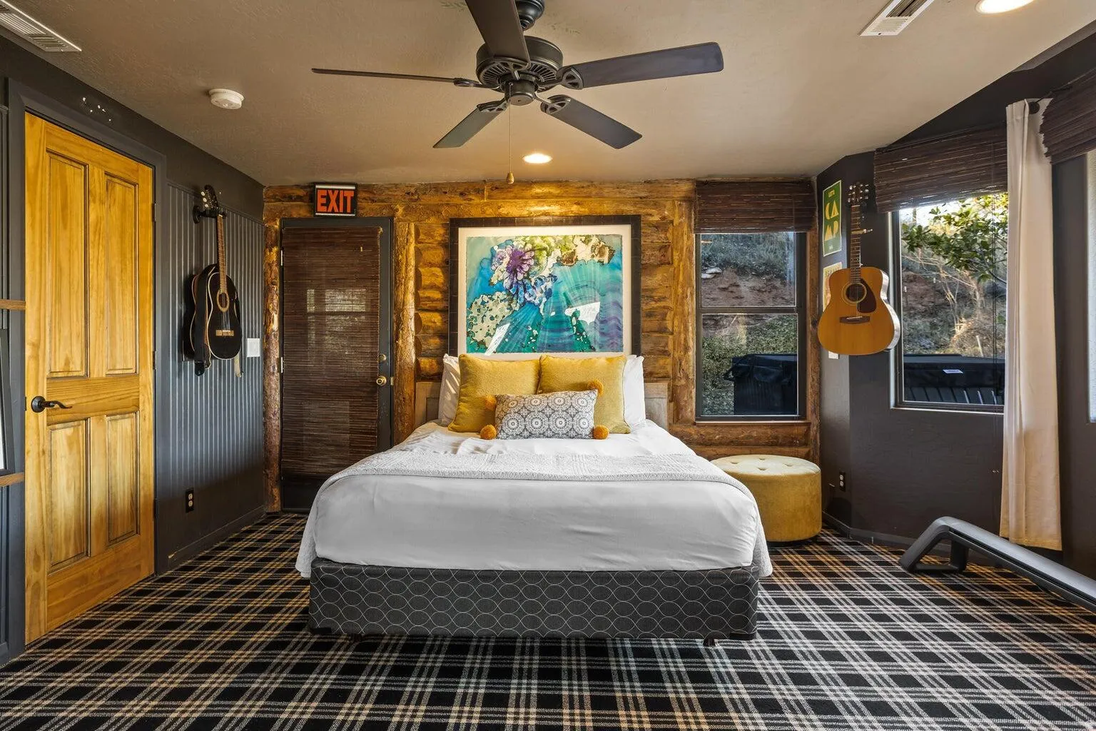 Room featuring plaid carpet, a ceiling fan, and exposed wood wall accents