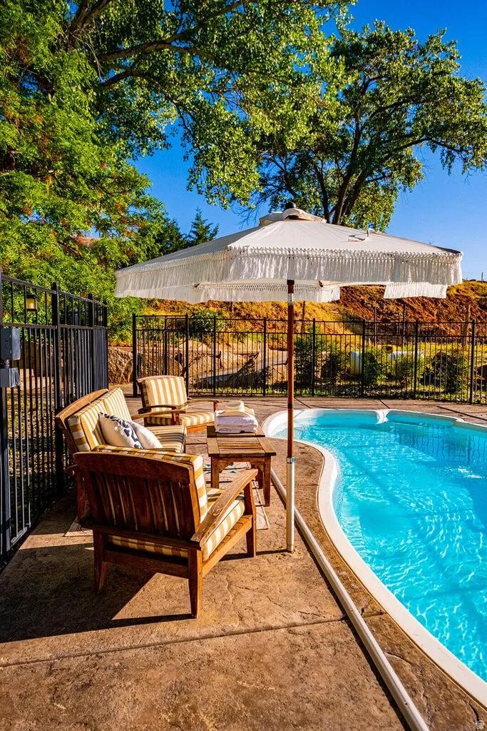 Outdoor swimming pool featuring a curved border and a stamped concrete surround