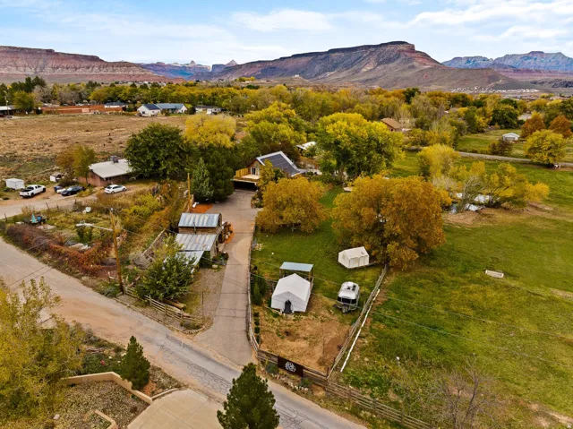 Expansive property featuring verdant fields and mature deciduous trees