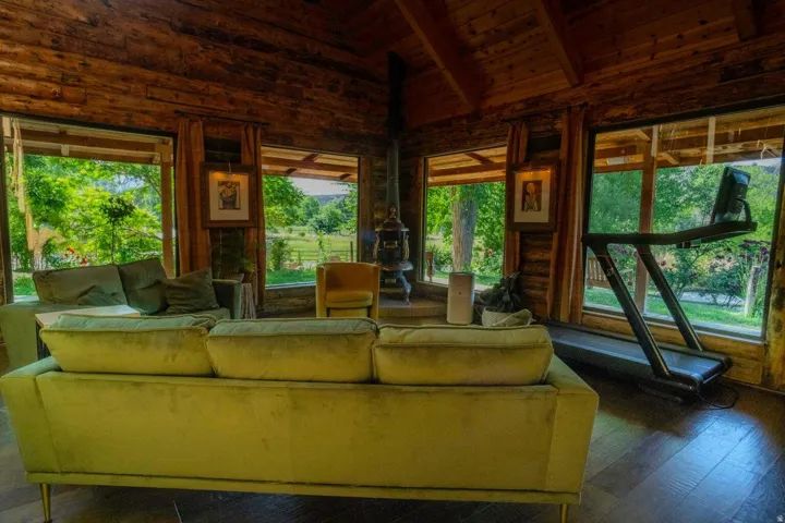 Spacious room featuring wood-finish flooring and extensive natural wood wall and ceiling paneling