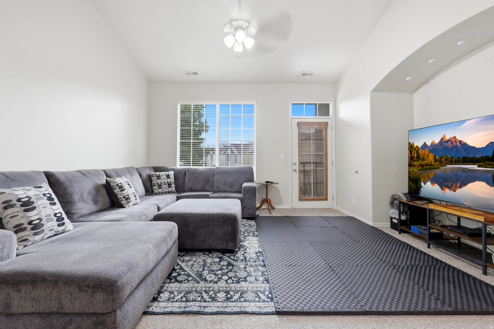 Vaulted ceilings complement the light-toned walls and window with horizontal blinds
