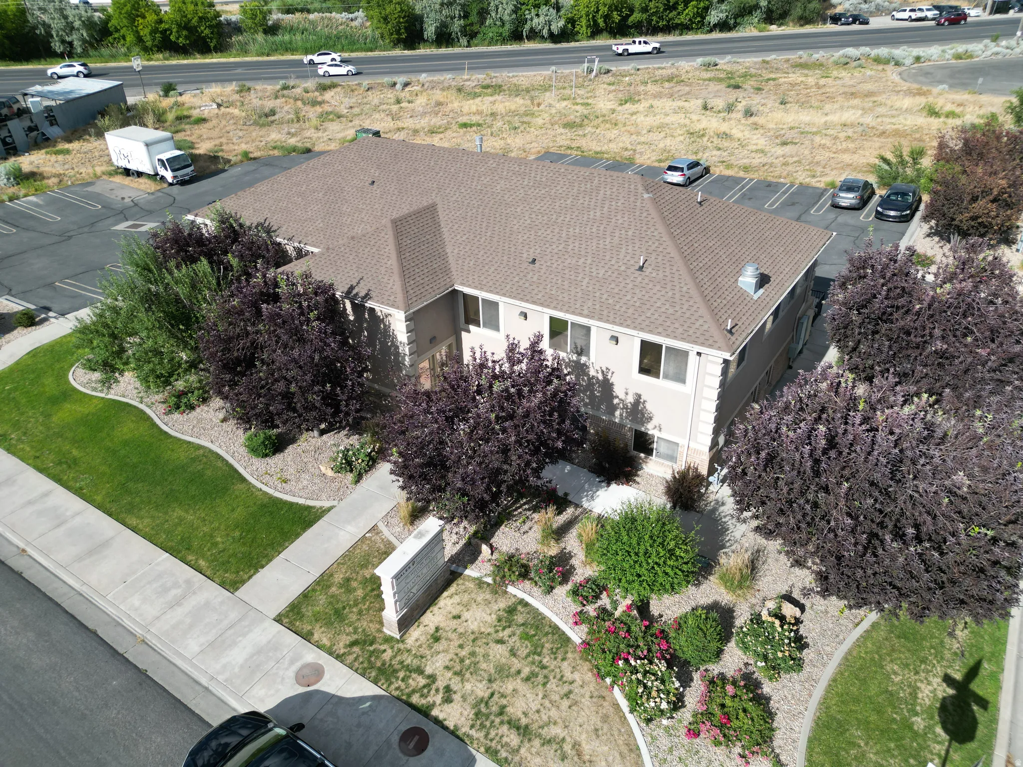 Two-story building with a light beige exterior and a brown shingle roof