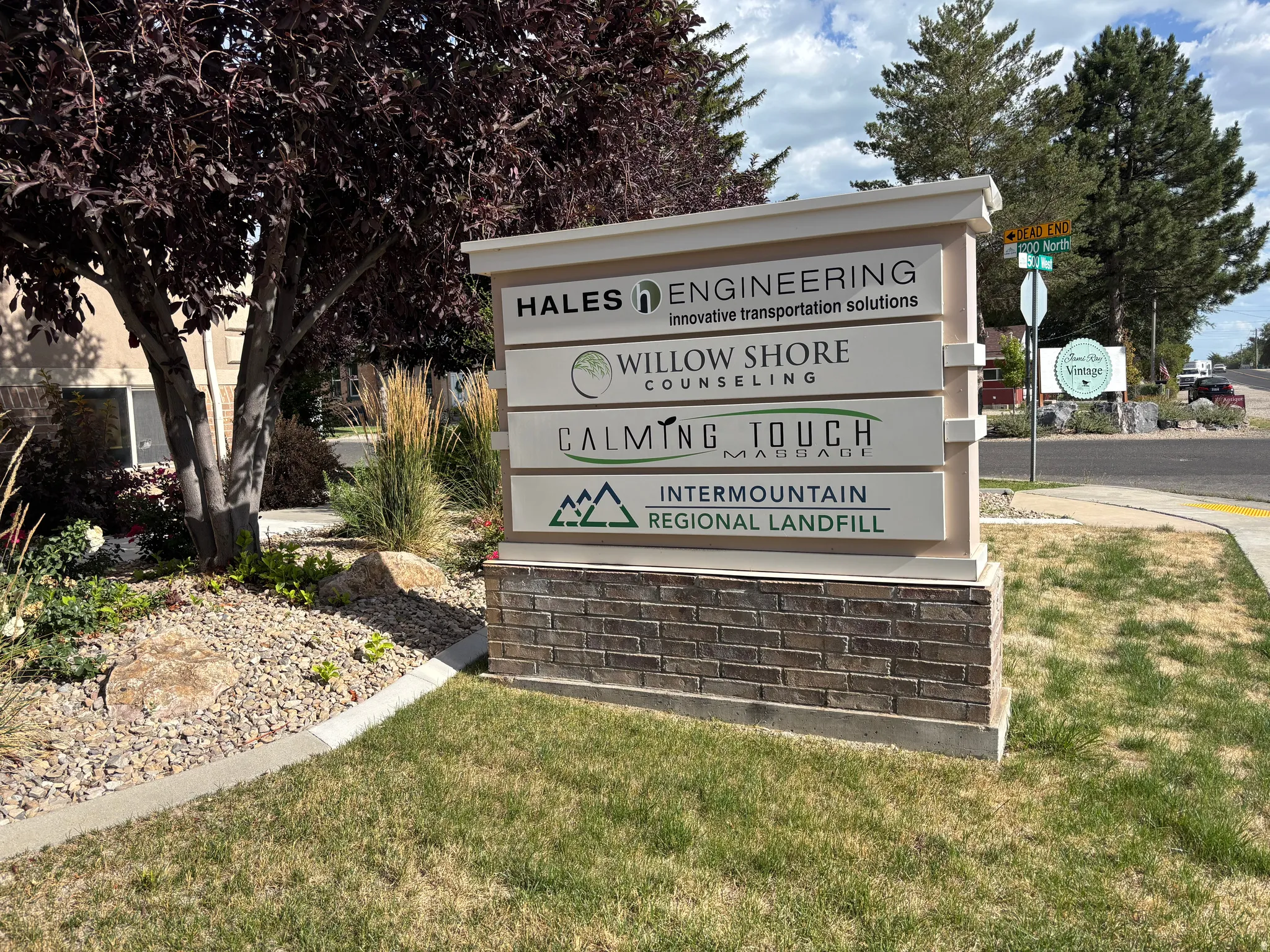 Business directory sign featuring a stone base, multiple business listings, and a white top cap